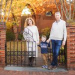 A family stands in front of an iron gate in Downtown Annapolis, posing for a beautiful portrait.