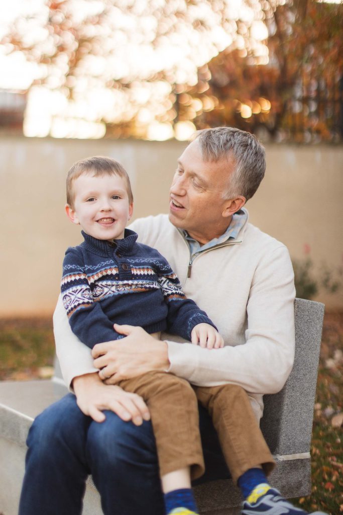 A father and son sitting on a bench in downtown Annapolis, enjoying the fall season.