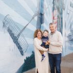 A family poses for a portrait in front of a mural in Downtown Annapolis.