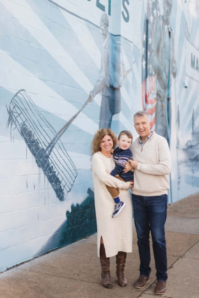 A family poses for a portrait in front of a mural in Downtown Annapolis.