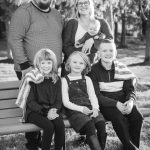 A black and white family portrait captured during sunset.