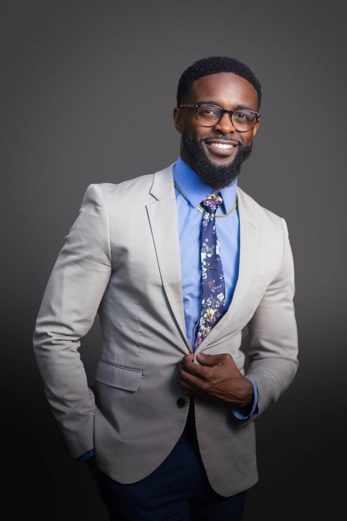 A man in a grey suit and tie posing for a Maryland headshot photo.