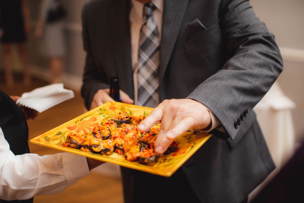 A man in a suit holding a plate of food at the Anchor Inn in Annapolis, Maryland.