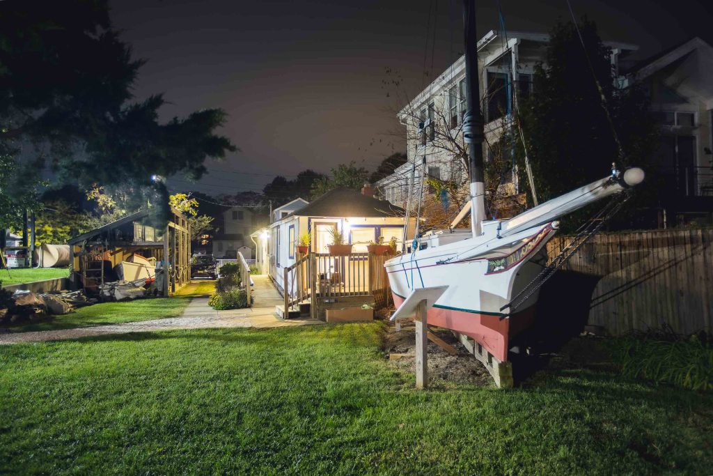 A sailboat is parked in a yard at night in Annapolis, Maryland.