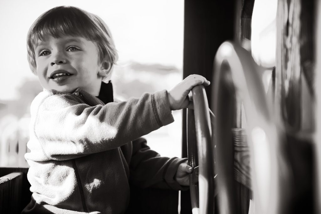 A black and white photo of a young boy on a train at the B&O Railroad Museum in Maryland.