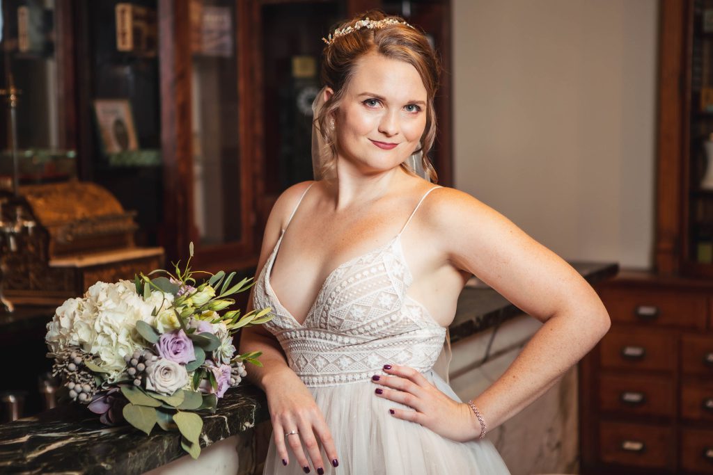 A bride in a wedding dress posing in front of a bar at the Baltimore Museum of Industry.