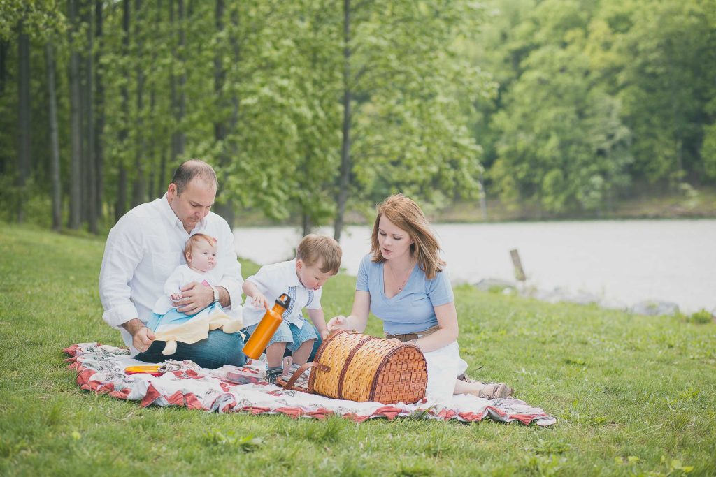 A family enjoys a picnic on a blanket near Black Hill Regional Park in Maryland.