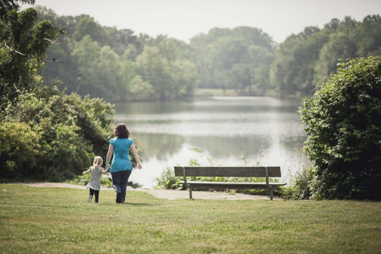 A woman and a child walking by Attick Lake in Greenbelt, Maryland.