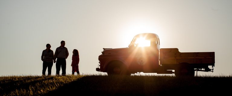 A silhouette of a family standing in front of a truck at sunset in Germantown, Maryland.