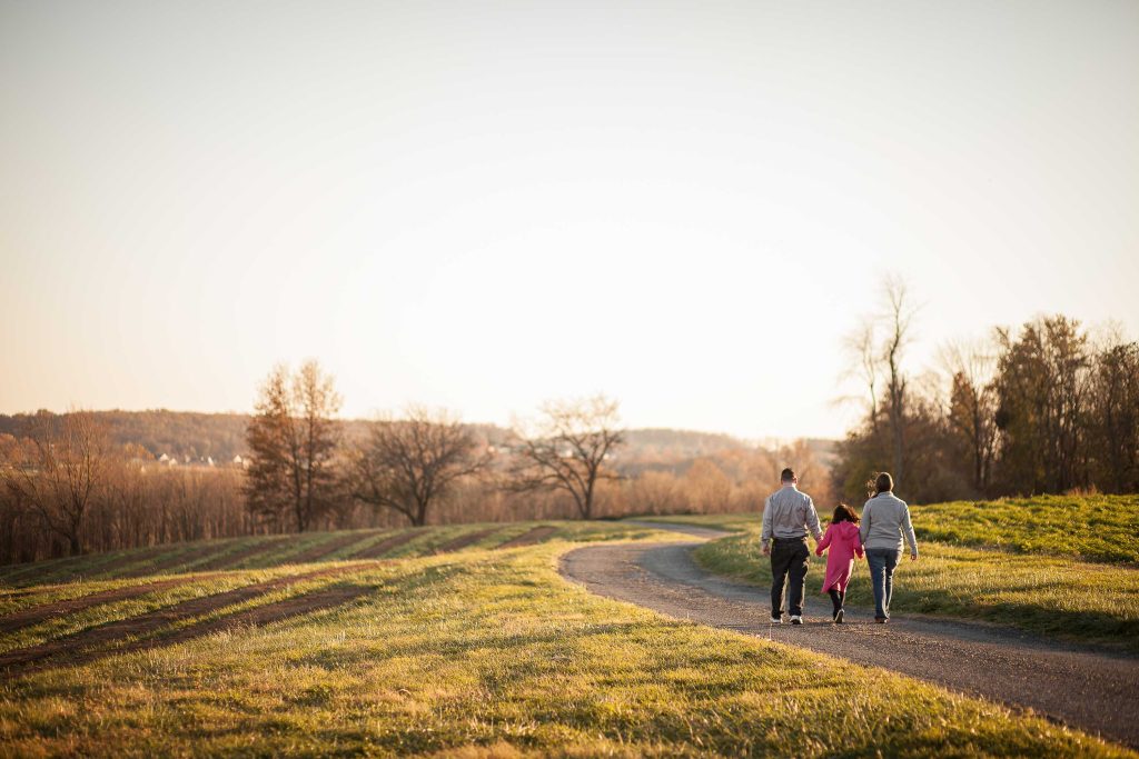 A family walks down a dirt road at Butler's Orchard in Maryland near Germantown.