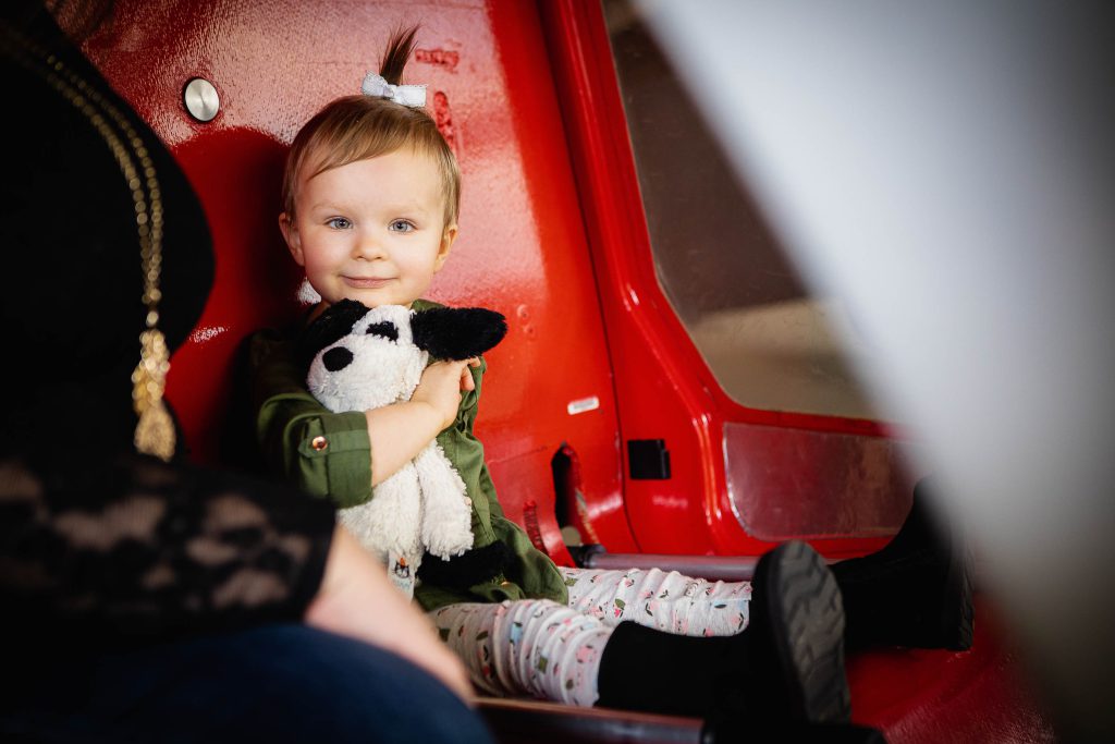 A little girl sitting in a red car at the College Park Aviation Museum in College Park, Maryland.