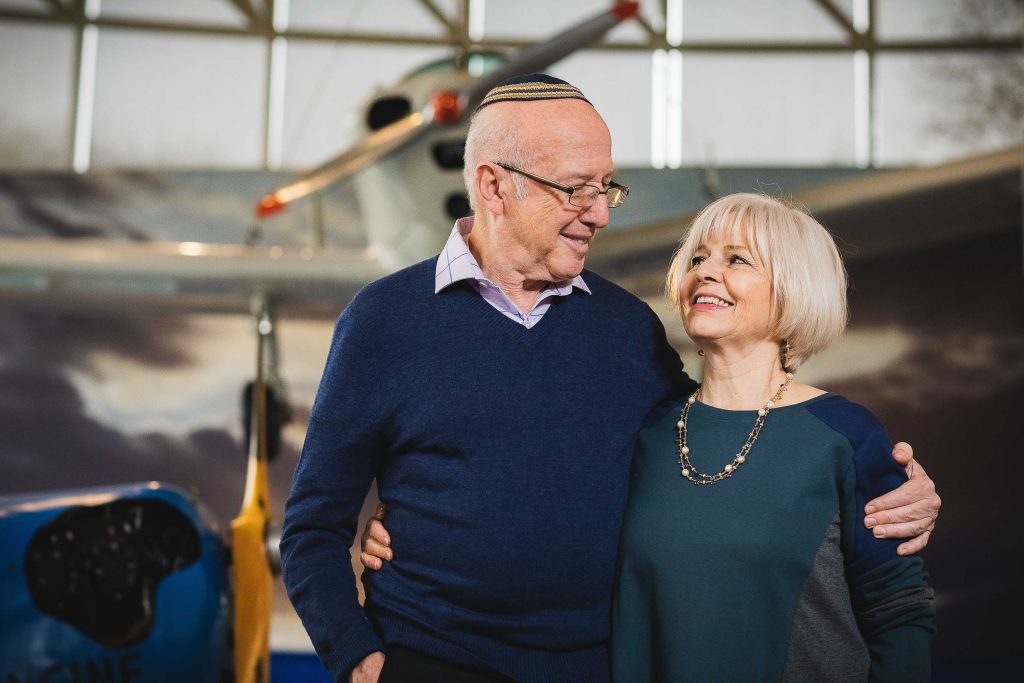 An older couple standing in front of an airplane at the College Park Aviation Museum in Maryland.