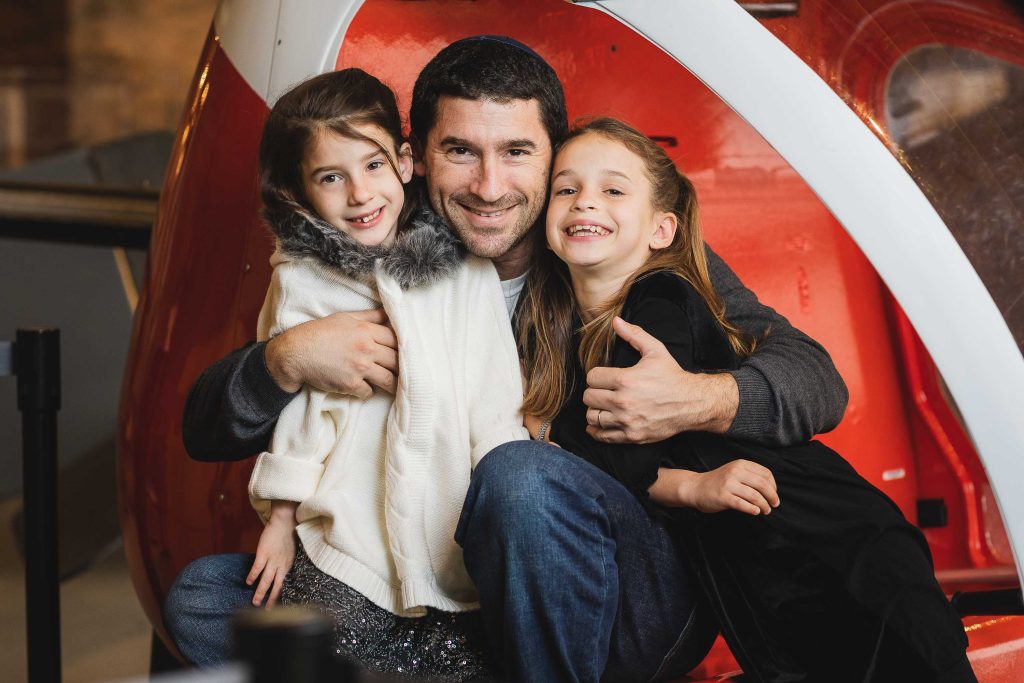 A man and his two daughters are posing for a photo at the College Park Aviation Museum in Maryland.