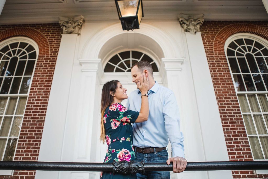 A couple kisses in front of a brick building in Downtown Annapolis during their engagement session.