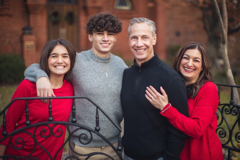 A family posing for a photo in front of an iron fence in Downtown Annapolis.
