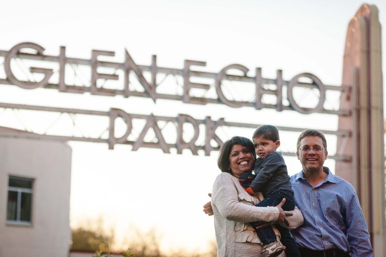 A family poses in front of a sign that says Glen Echo Park.