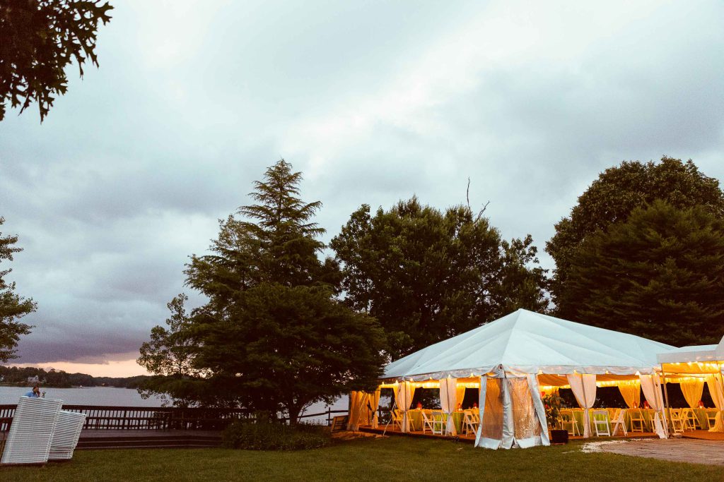 A white tent is set up on a grassy area near a lake in Annapolis, Maryland.
