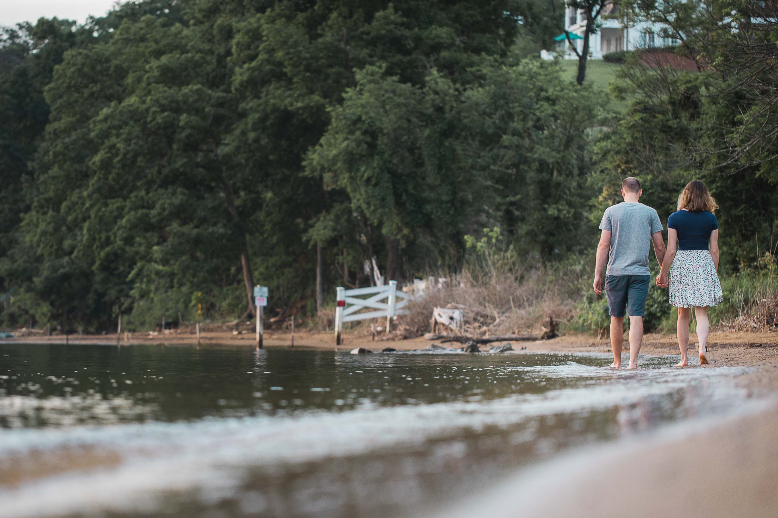 A couple walking along the shore of a lake in Jonas and Anne Catharine Green Park, Maryland.
