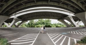 A man and woman are standing under a bridge in Jones Point Park in Alexandria, Virginia.