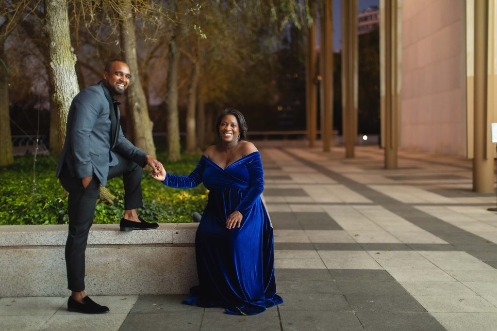 A couple leaning against a wall at night on the Kennedy Center Grounds in Washington DC.