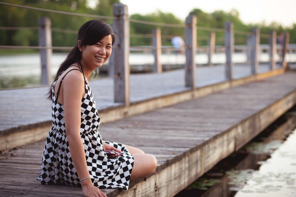 A woman sitting on the wooden dock at Lake Artemesia in College Park, Maryland.
