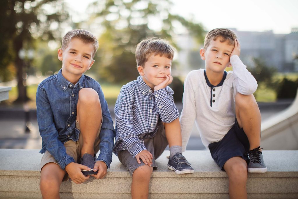 Three boys sitting on a bench in front of the Library of Congress in Washington DC.