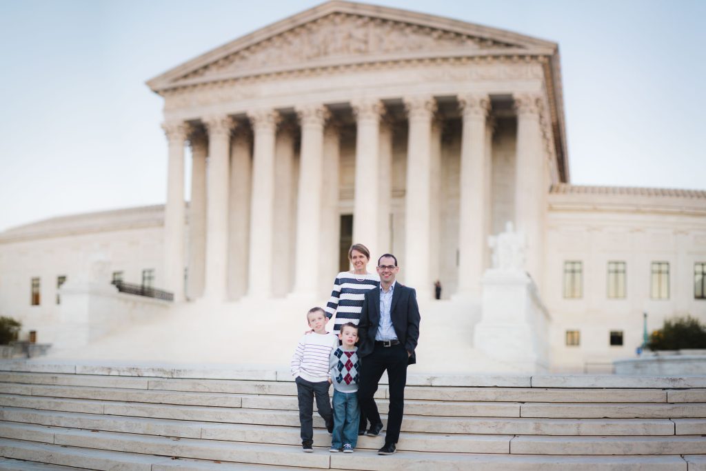 A family posing in front of the Library of Congress building in Washington DC.