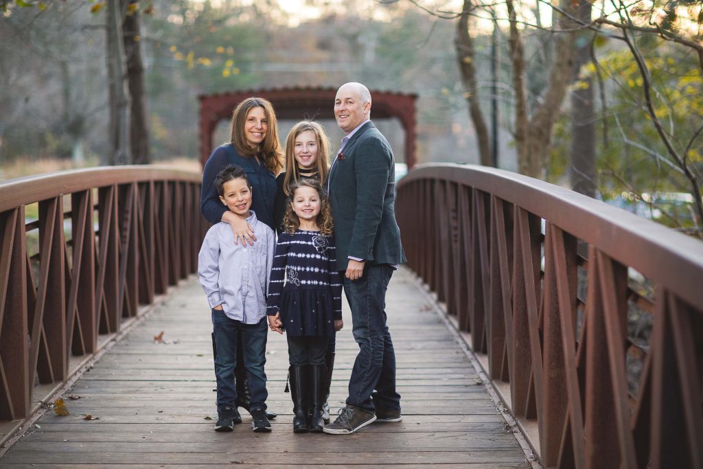 A family posing on a bridge at Locust Grove Nature Center in Maryland.