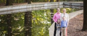 A family is posing in front of a pond on Theodore Roosevelt Island.
