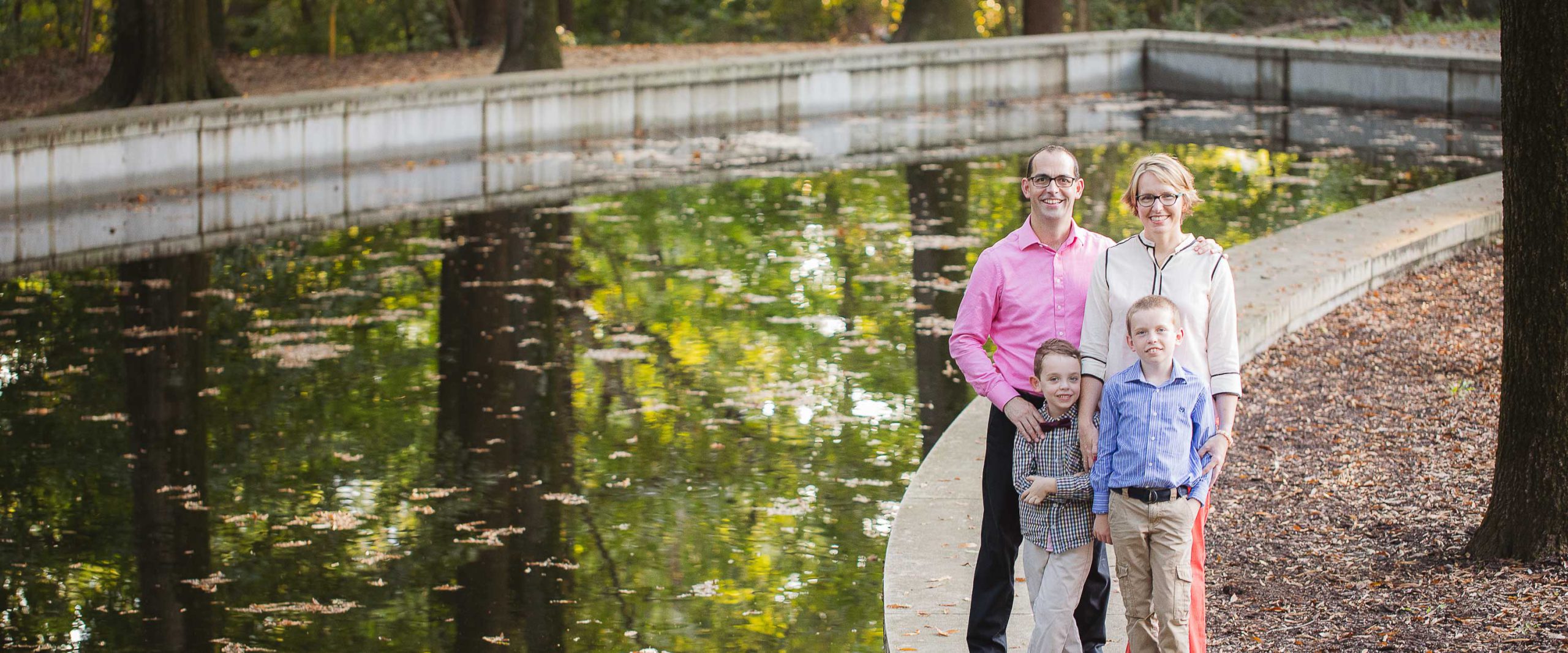 A family is posing in front of a pond on Theodore Roosevelt Island.
