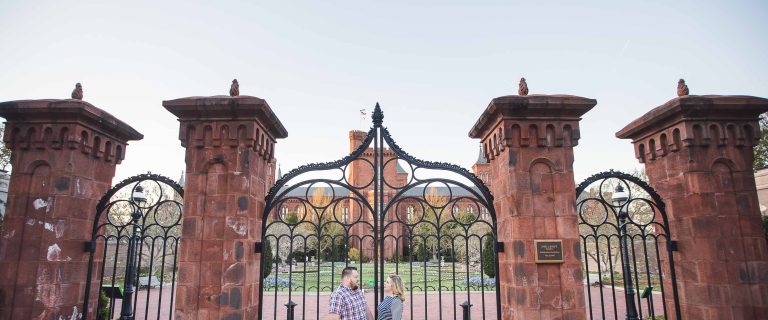 A couple standing in front of an iron gate at Enid Haupt Garden in Washington DC.