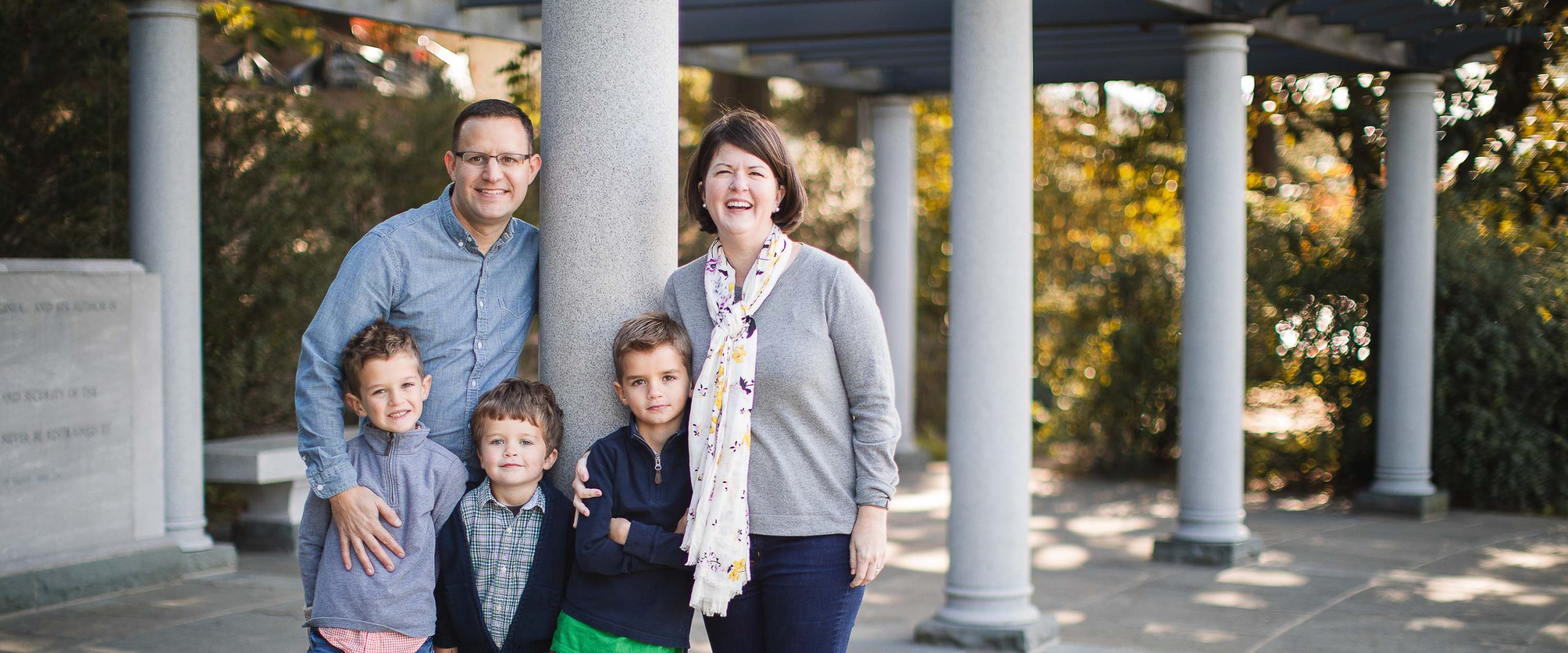 A family is posing for a photo in front of the George Mason Memorial in Washington DC.