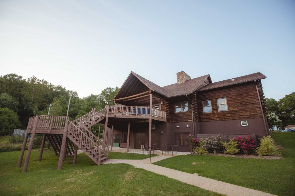 A log cabin with stairs leading up to a deck located in Germantown, Maryland.