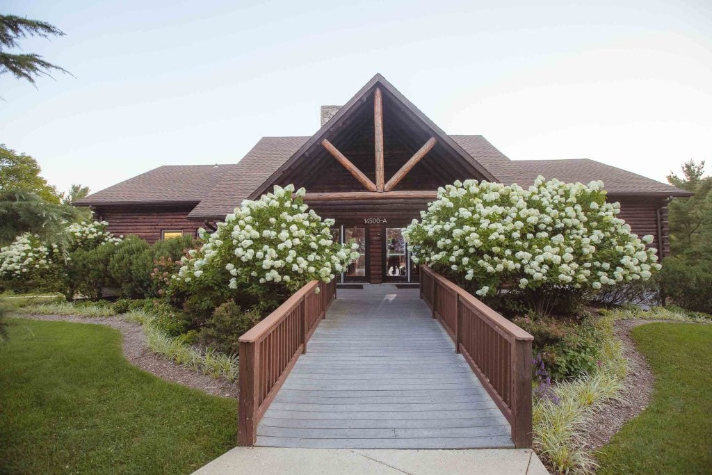 The Great Seneca Lodge, a log cabin in Germantown, Maryland, connected by a wooden walkway.