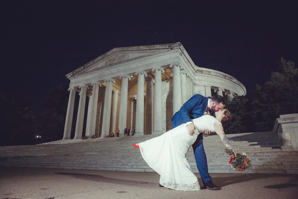 A bride and groom kiss at the Jefferson Memorial in Washington DC.