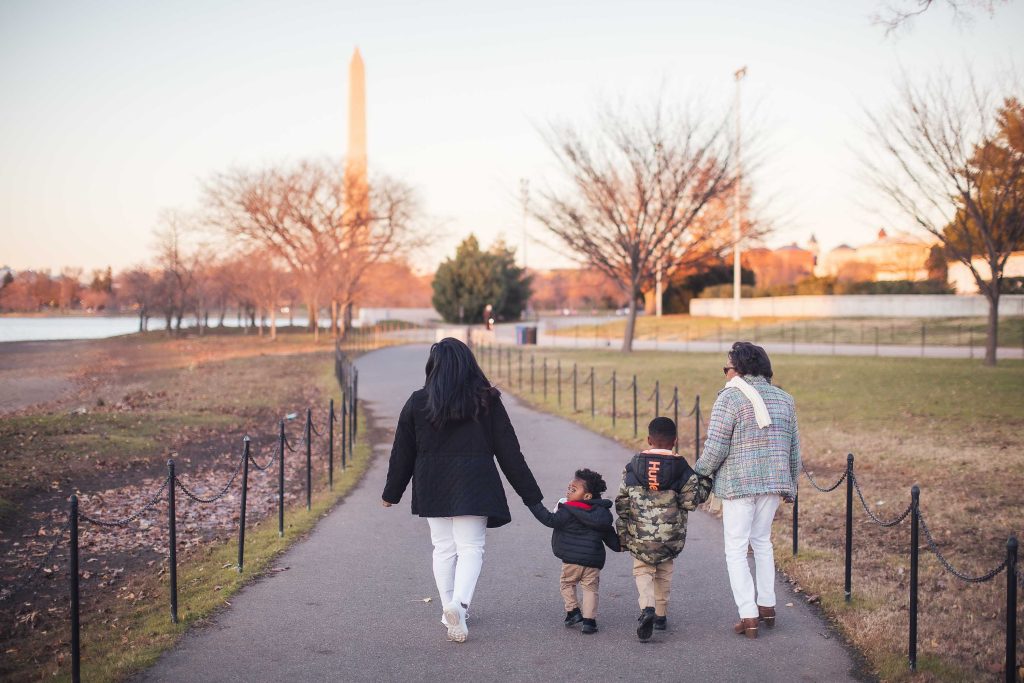 A family walks along a path near the Washington Monument in Washington DC.
