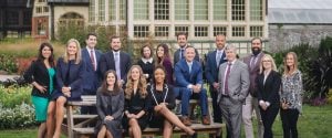 A group of business people posing on a bench in Rawlings Conservatory, Baltimore.