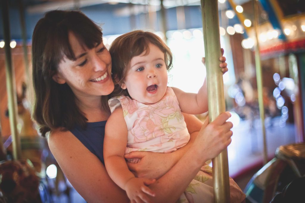 A woman holding a baby on a carousel at Watkins Park in Upper Marlboro, Maryland.