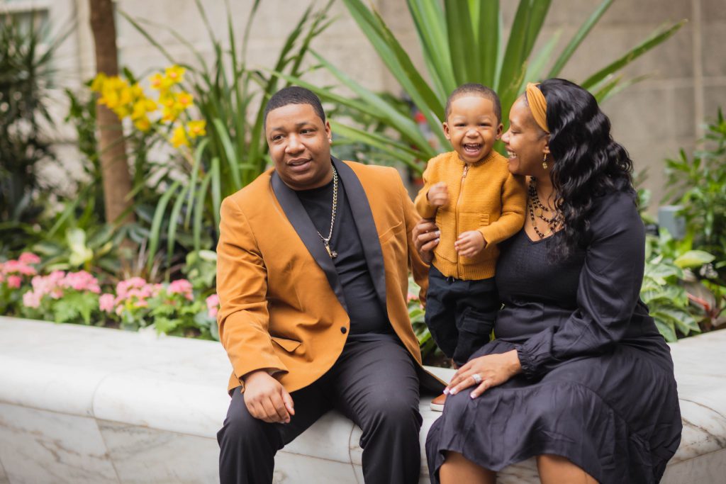 A family sits on a bench at the National Portraits Gallery with their young son.