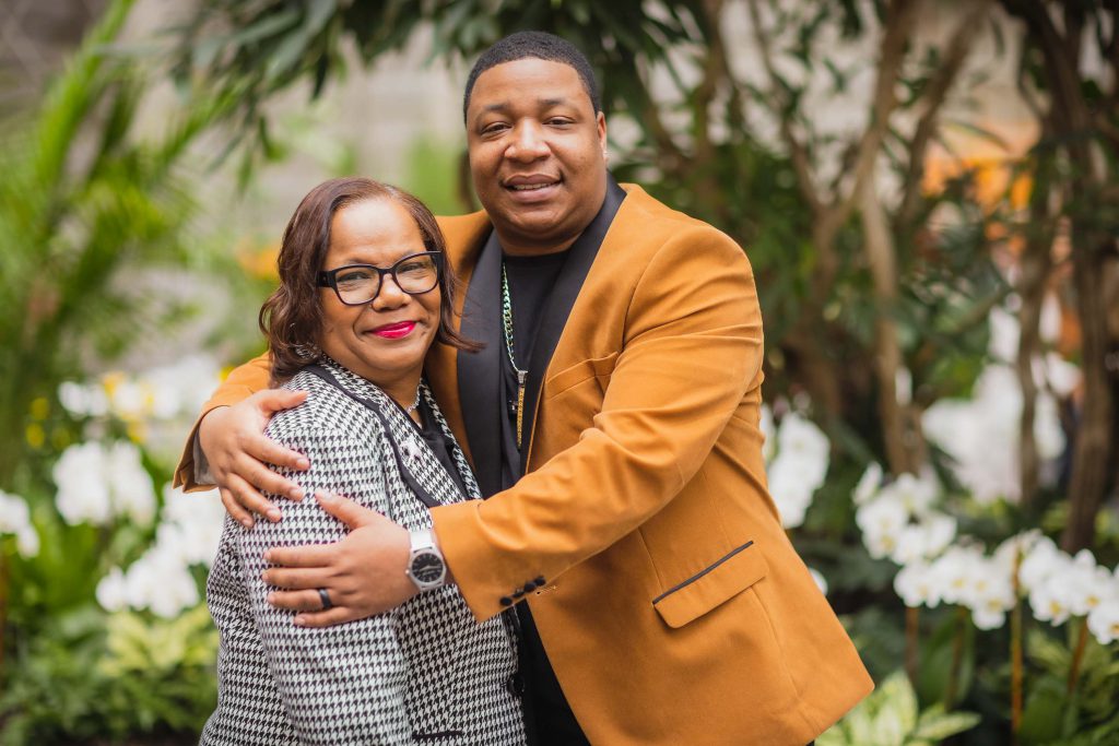 A family embracing in front of plants at the National Portraits Gallery.