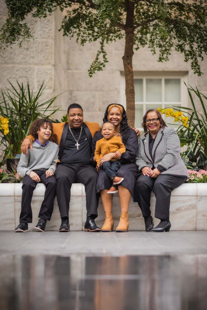 A family sits on a bench in front of the National Portraits Gallery.