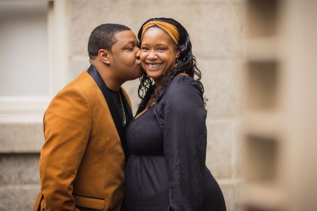 A pregnant couple posing romantically in front of the National Portraits Gallery.