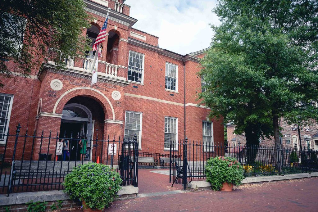 A red brick building in Annapolis with a fence and an American flag.