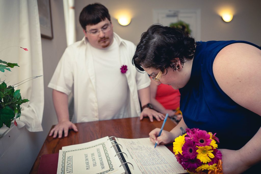 A man and a woman signing a wedding book at the Circuit Court for Anne Arundel County in Maryland.