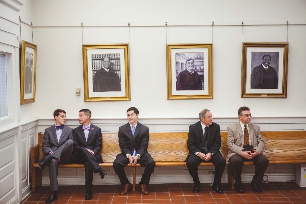 A group of men sitting on a bench in the Circuit Court for Anne Arundel County, Maryland.