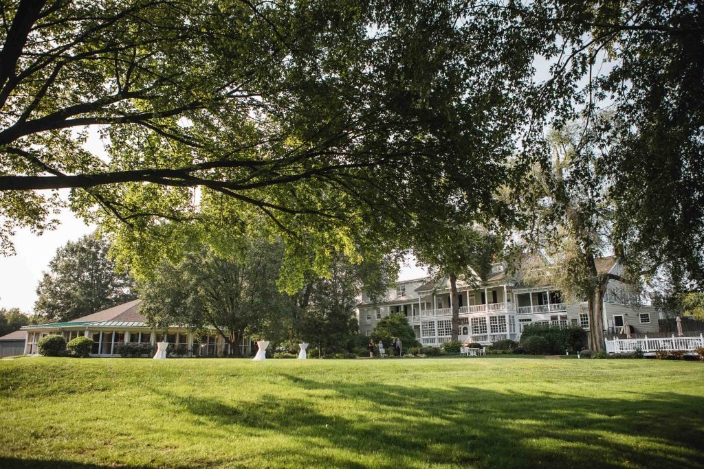 A large lawn with trees and a house in the background.