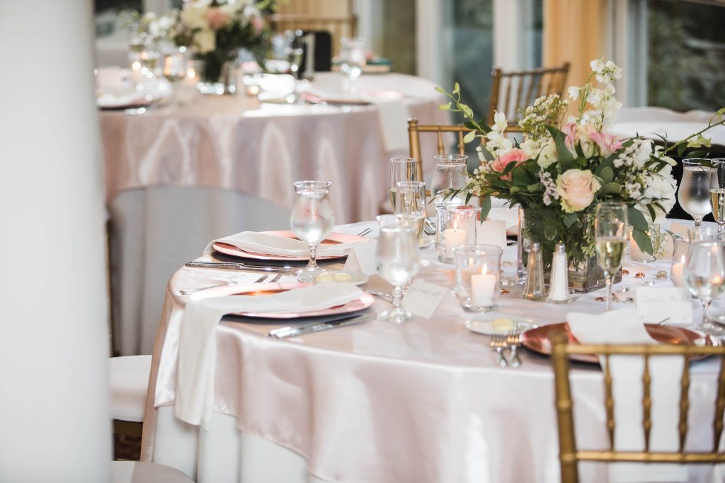 A table setting with pink flowers and white linens at Kent Island Resort in Stevensville, Maryland.