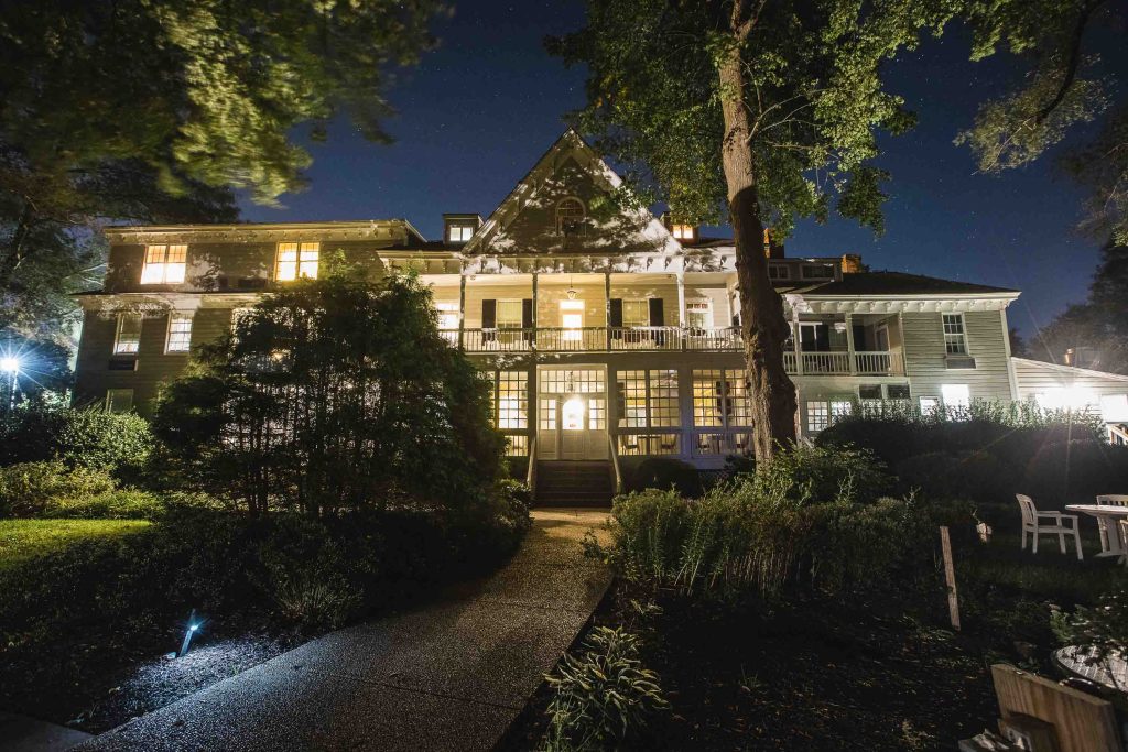 Kent Island Resort in Maryland showcases a beautifully lit house at night, framed by trees in the background.