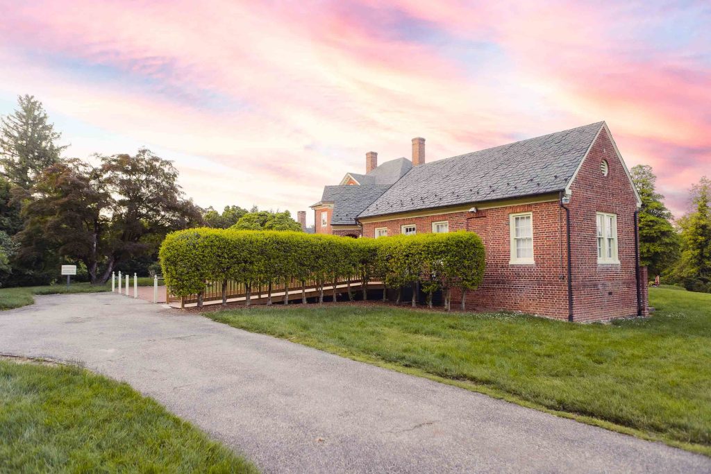 Montpelier Mansion in Laurel, Maryland, featuring a brick house with bushes at sunset.