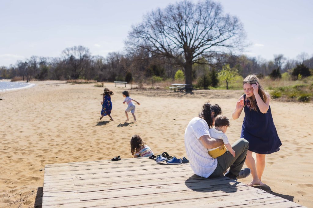 A family sits on a wooden dock on the Chesapeake Bay in Maryland.